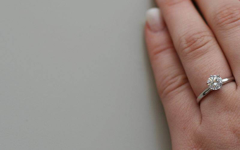 800px-Diamond_engagement_ring_on_woman_hand_6313